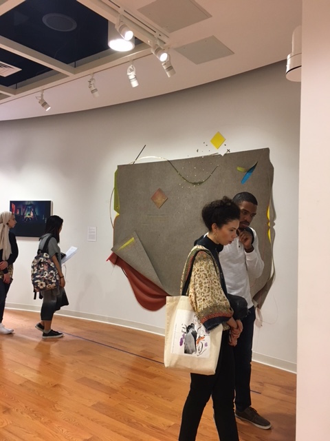 Two students stand in front of artwork